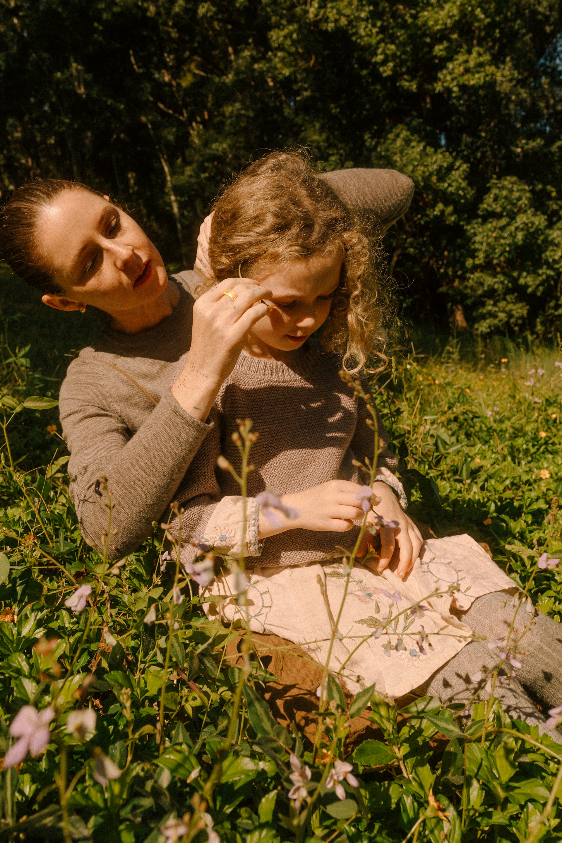 A mother wearing an Oura Ring while fixing her daughter's hair. 