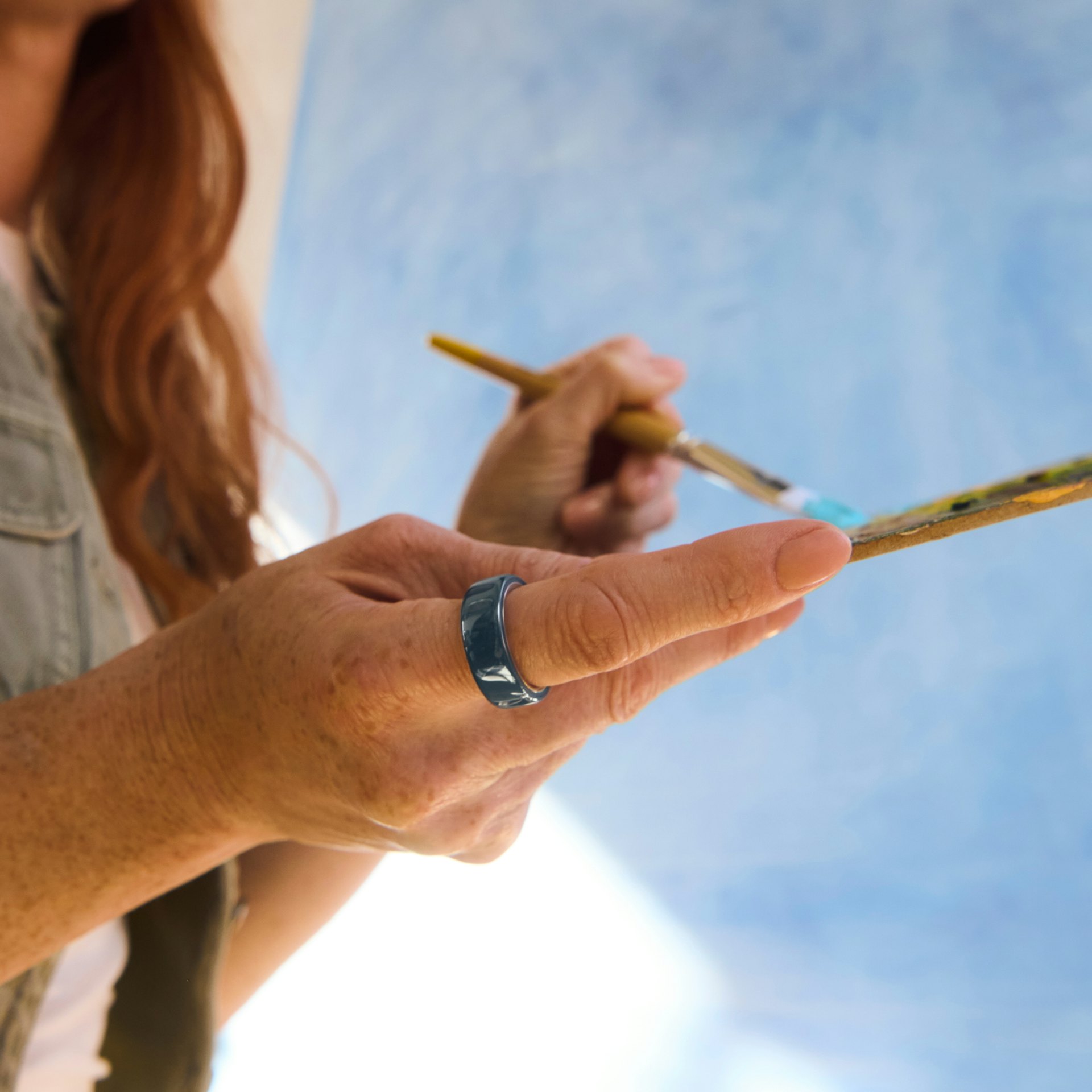 Close up of a person's hand with a Midnight Oura Ring 4 Ceramic on their finger